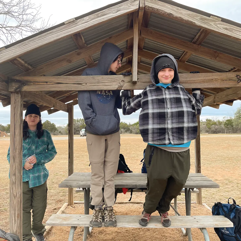 Children playing under a pavilion with a picnic table at Pedernales Falls State Park