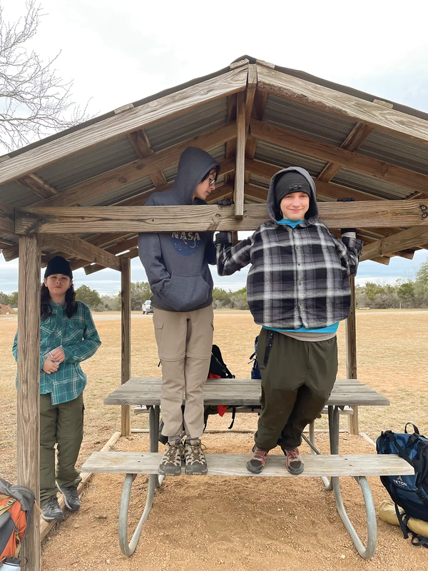 Children playing under a pavilion with a picnic table at Pedernales Falls State Park