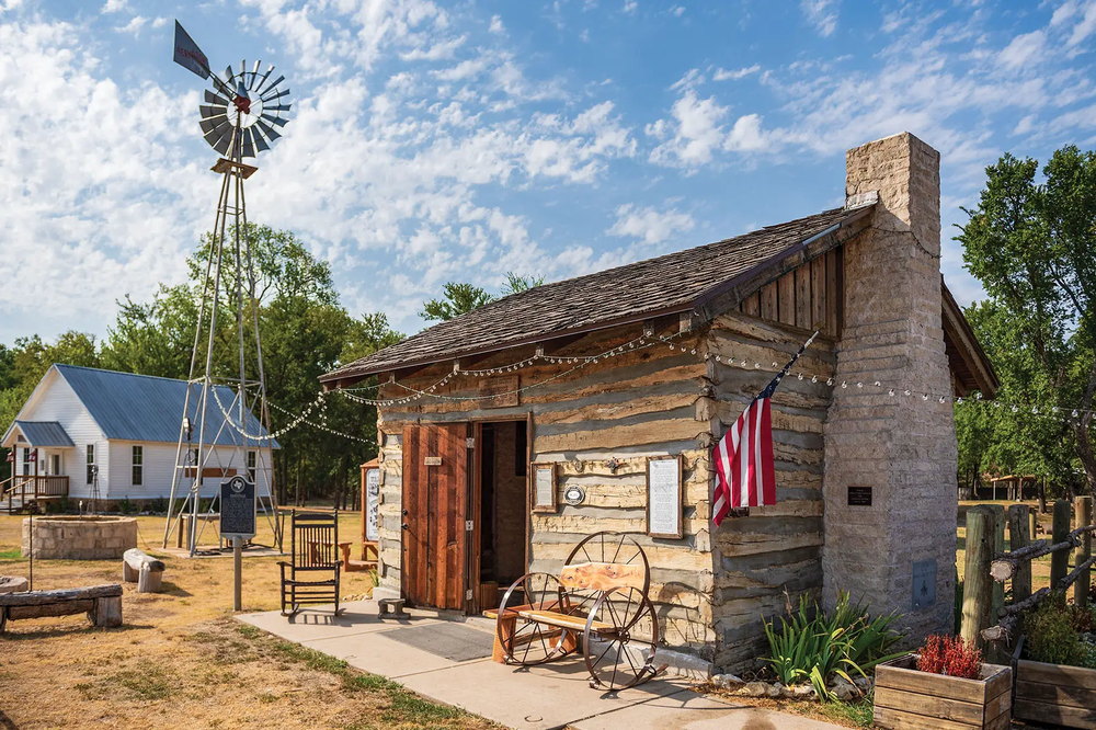 Cleburne re-created town of Wardville with a wooden structure with a brick chimney, and American flag and rocking chair