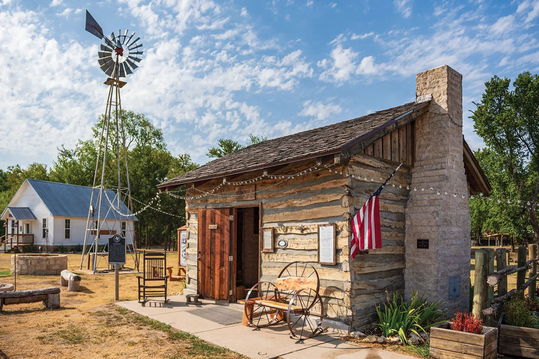 Cleburne re-created town of Wardville with a wooden structure with a brick chimney, and American flag and rocking chair