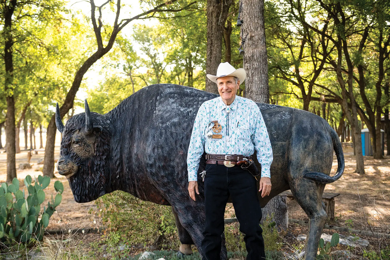 Cleburne man in cowboy hat standing in front of bison statue