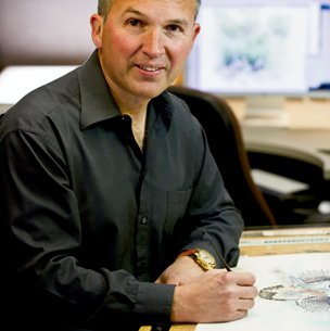 Clement Guzman at his desk sketching