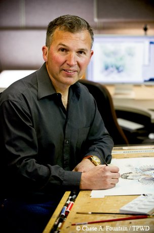 Clement Guzman at his desk sketching