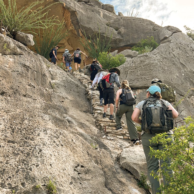 Hikers climbing to White Shaman mural in the Lower Pecos canyonland