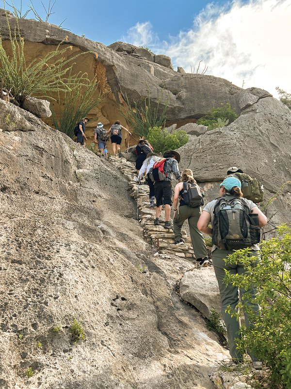 Hikers climbing to White Shaman mural in the Lower Pecos canyonland