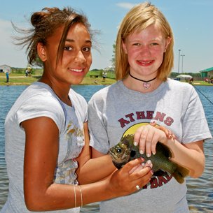 Two girls smile with their bluegill catch
