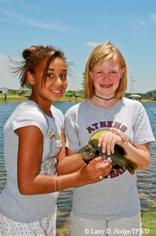 Two girls smile with their bluegill catch