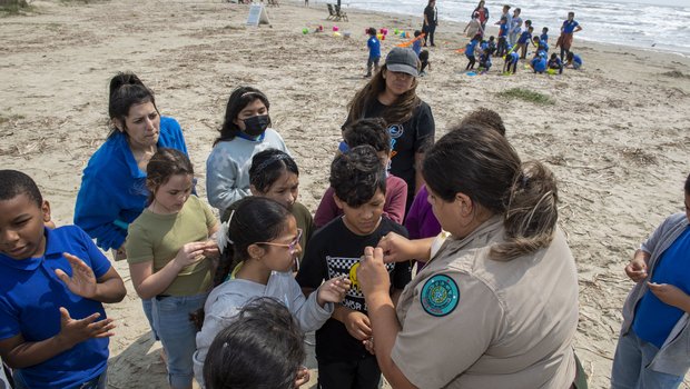 Park ranger at Galveston Island State parks teaching children on the beach