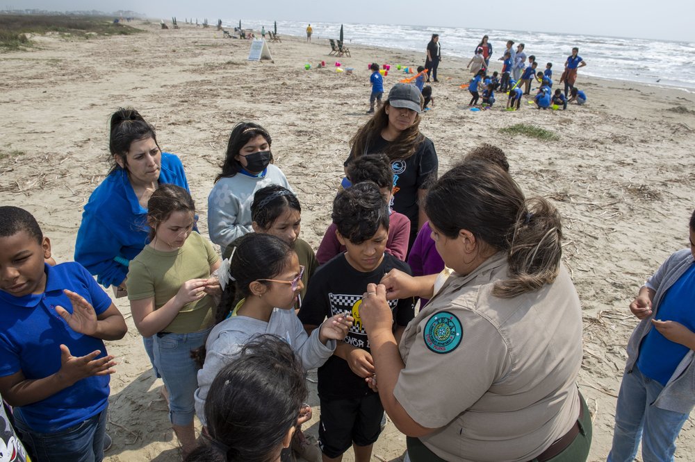 Park ranger at Galveston Island State parks teaching children on the beach