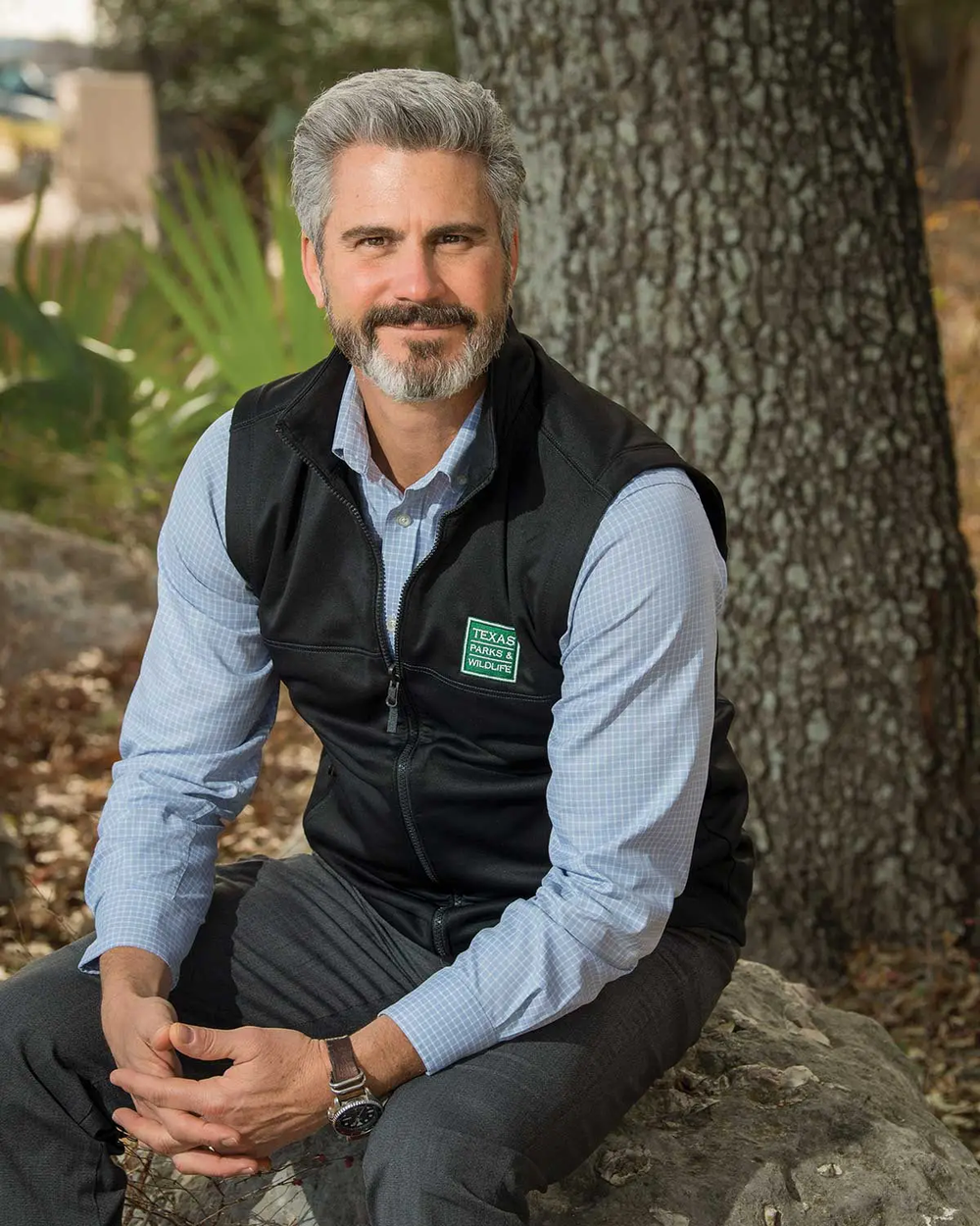 David-Yoskowitz executive Directory for TPWD sitting on a boulder in front of a tree