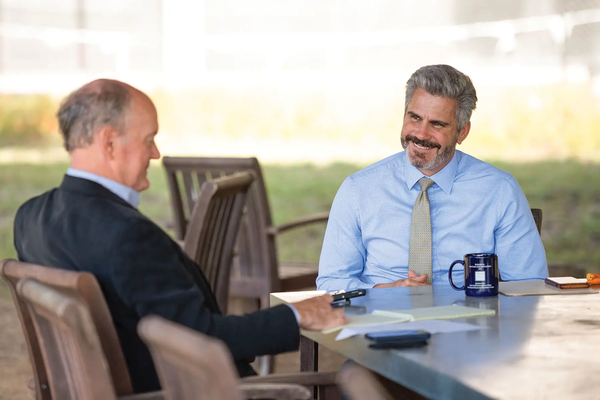 David Yoskowitz interviewed by editor Russell Roe at a table with papers and a coffee cup