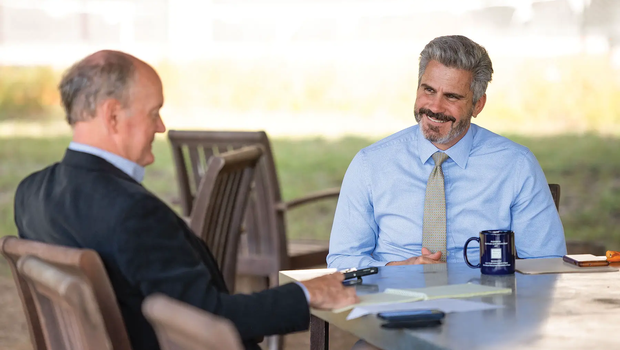 David Yoskowitz interviewed by editor Russell Roe at a table with papers and a coffee cup