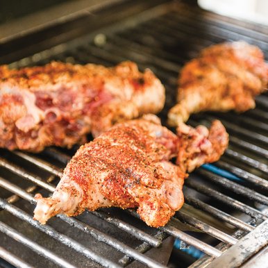 Feral hog being prepared in a smoker.