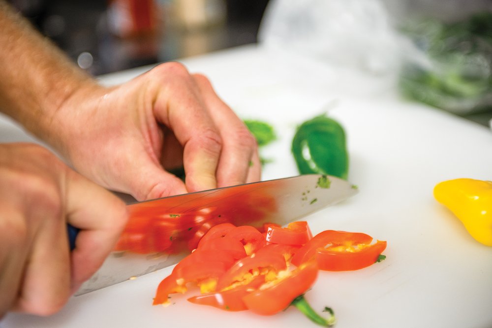 Person chopping peppers with a knife.