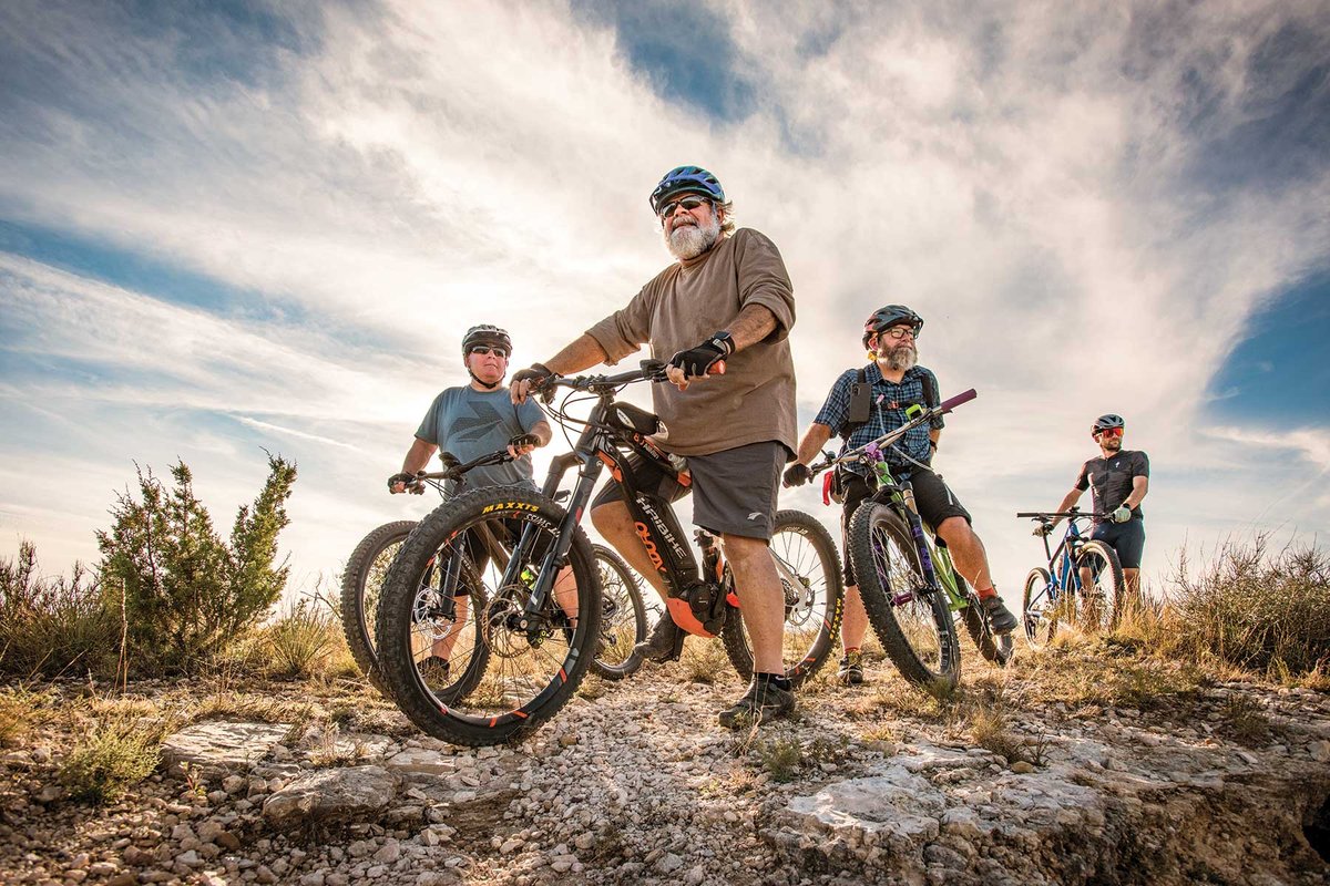 Four men on a bike trail.