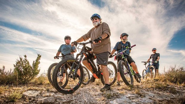 Four men on a bike trail.