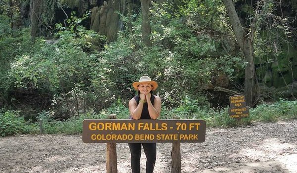Josie Gutierrez leaning on a Gorman Falls at Colorado Bend State Park.