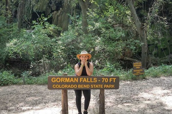 Josie Gutierrez leaning on a Gorman Falls at Colorado Bend State Park.
