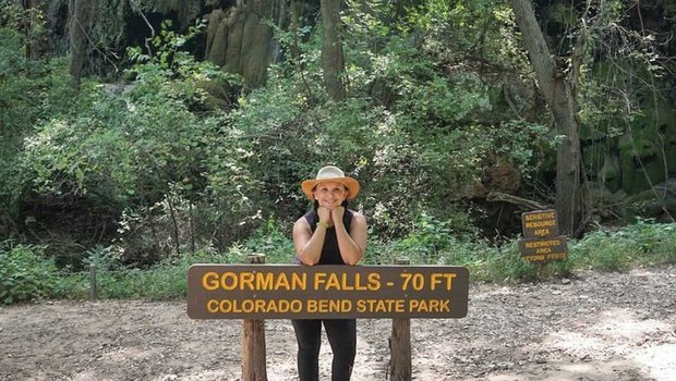 Josie Gutierrez leaning on a Gorman Falls at Colorado Bend State Park.