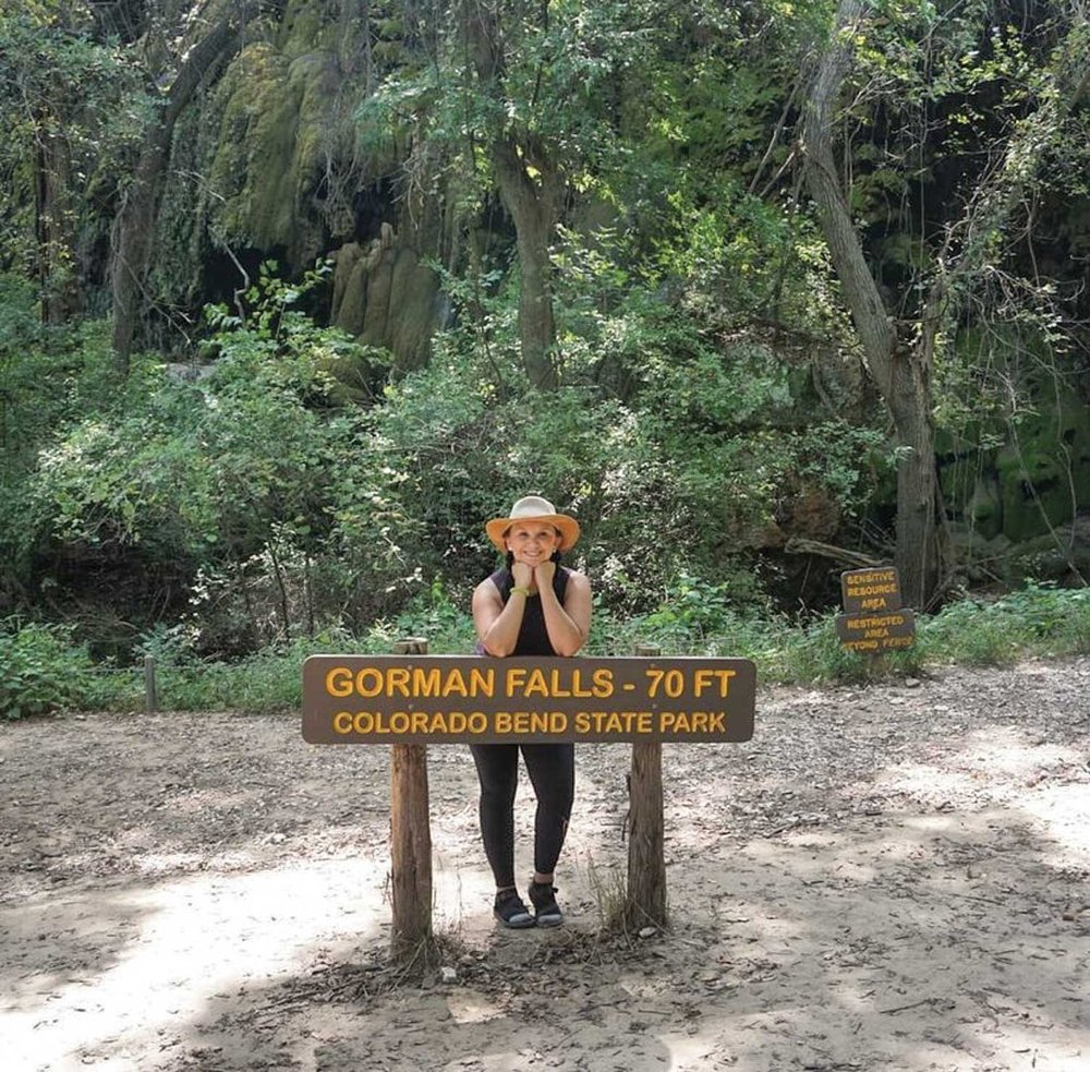 Josie Gutierrez leaning on a Gorman Falls at Colorado Bend State Park.