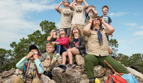 Guide and children wear solar glasses to view the solar eclipse