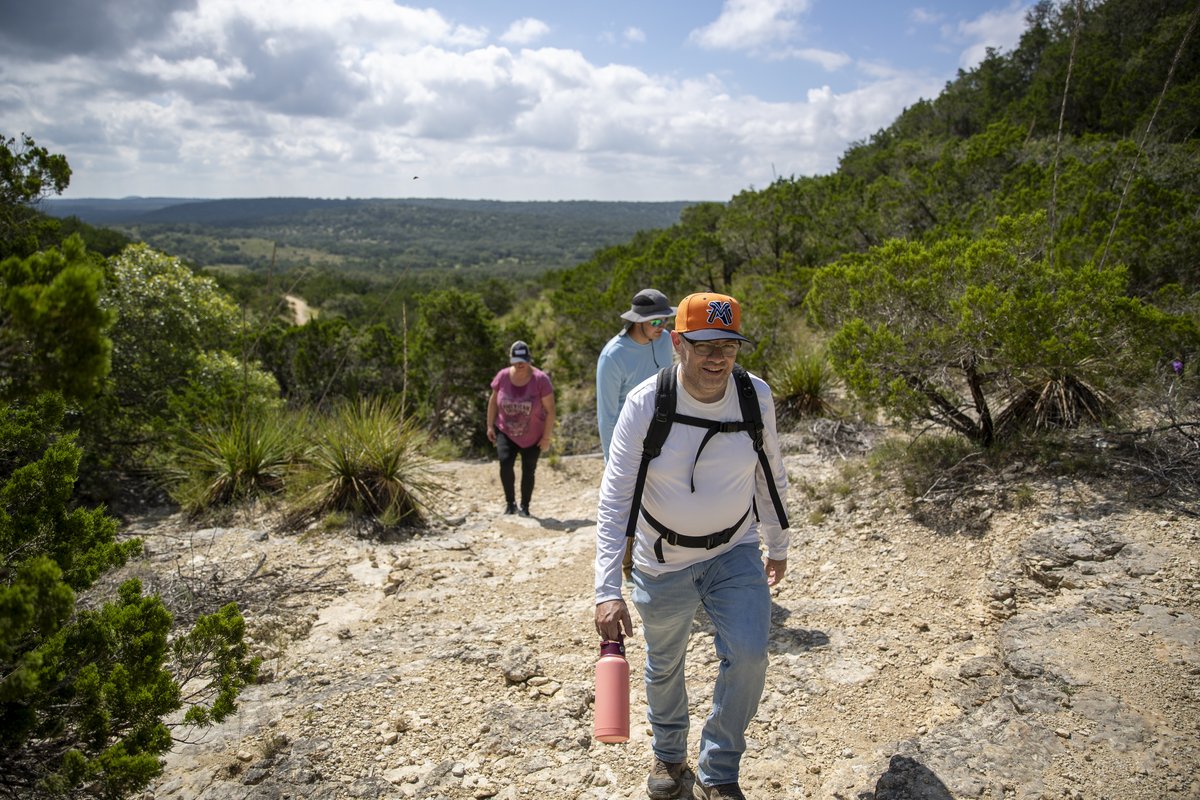 Family Hike in the hill country coming up a hill on a trail