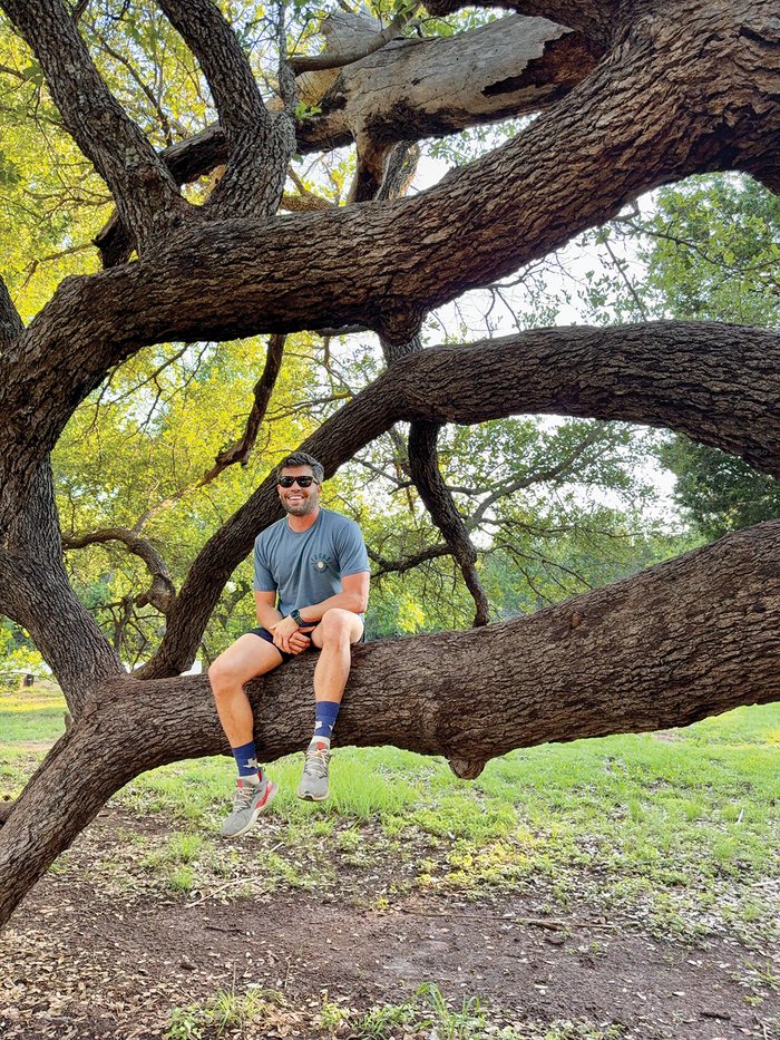 John Sorsby sitting on a tree limb at Abilene State Park.