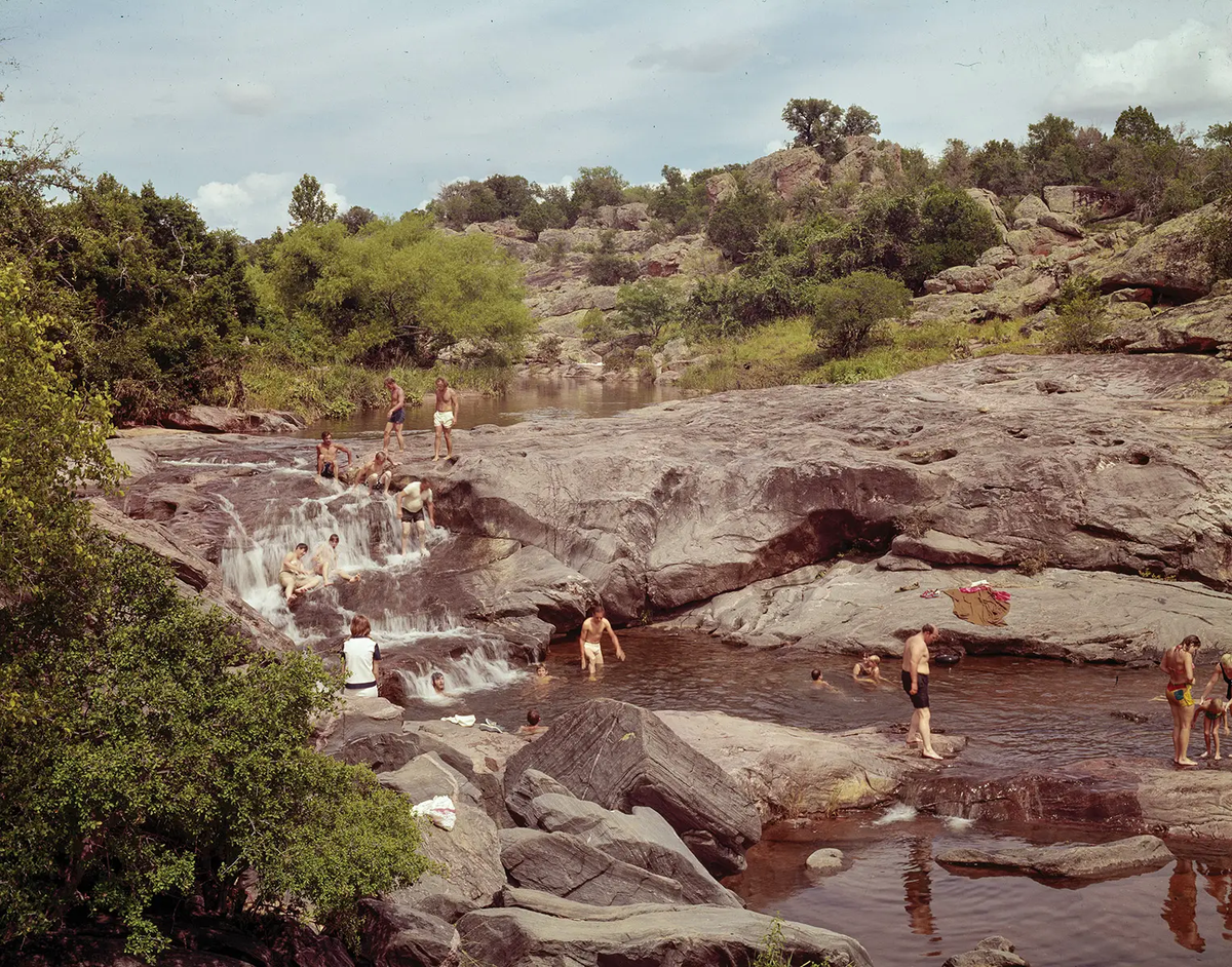 People at Inks Lake State Park splashing in the rocky pools