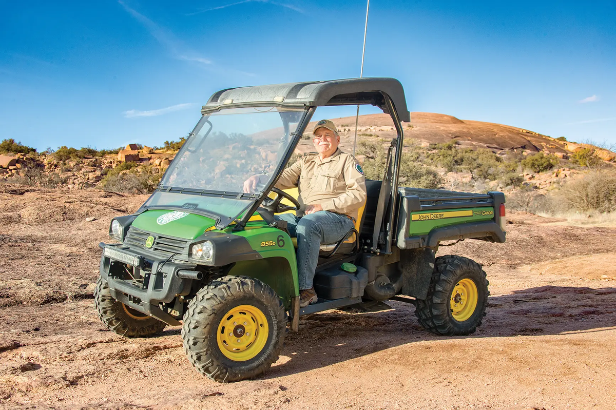 Jacky Lee a park host at Enchanted Rock State Natural Area in an all-terrain vehicle