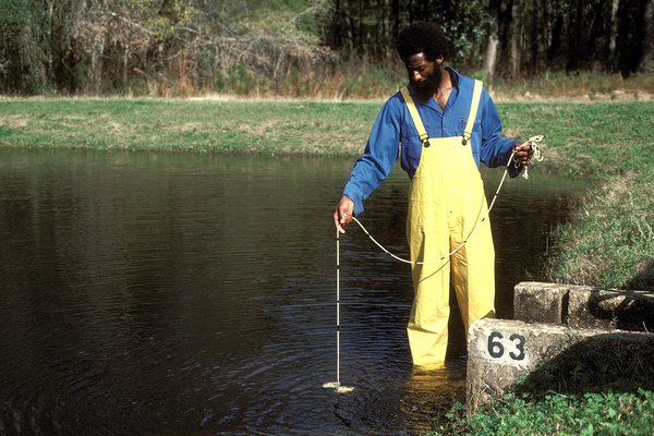 Man wading in the water at a the Jasper State Fish Hatchery