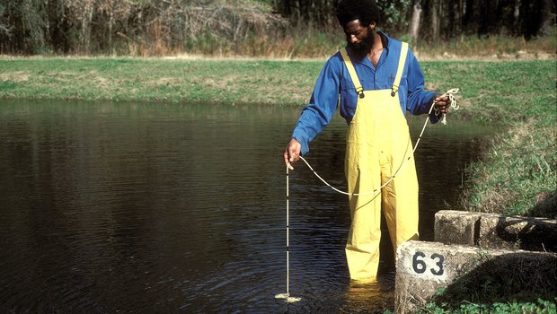 Man wading in the water at a the Jasper State Fish Hatchery