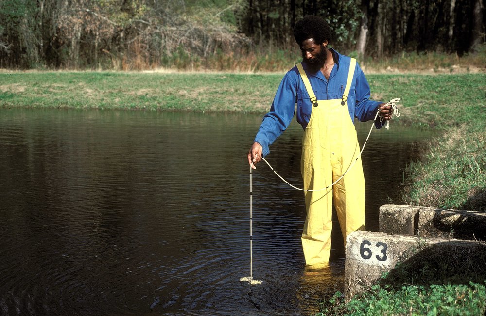 Man wading in the water at a the Jasper State Fish Hatchery