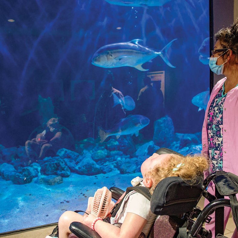 Juliana “Juju”at the Atlanta Aqarium watching fish swim in a tank.
