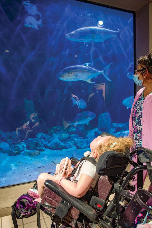Juliana “Juju”at the Atlanta Aqarium watching fish swim in a tank.