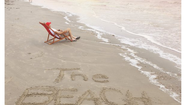 July 2024 cover of Texas Parks & Wildlife magazine, depicting a beach chair and the words 'The Beach Issue' written on the sand