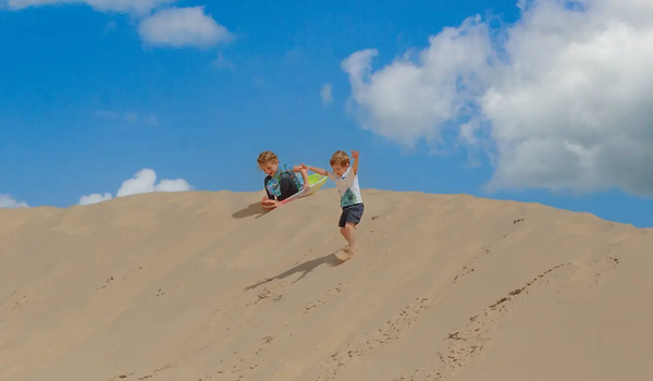 Kids sliding down the sand dunes at Monahans State Park