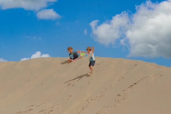 Kids sliding down the sand dunes at Monahans State Park