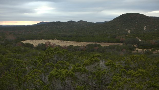 Kronkosky State Natural Area with a hill in the background an a river running through a field of trees