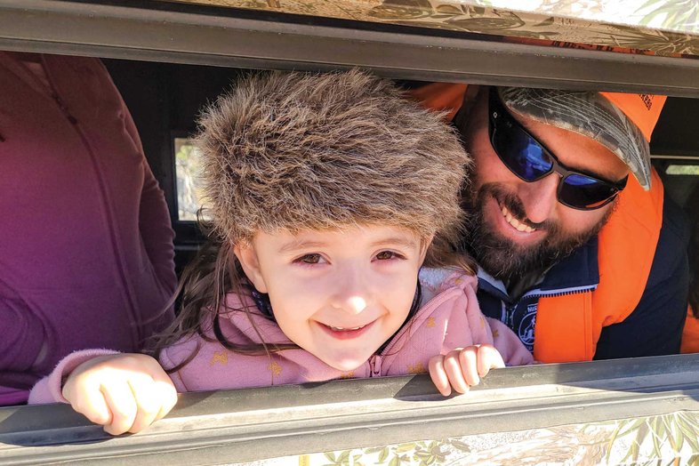 Man and child looking out a window in a deer blind.