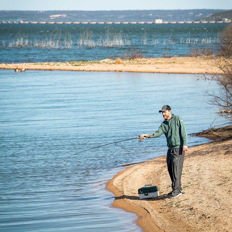 Man fishing at the edge of a lake