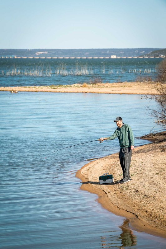 Man fishing at the edge of a lake