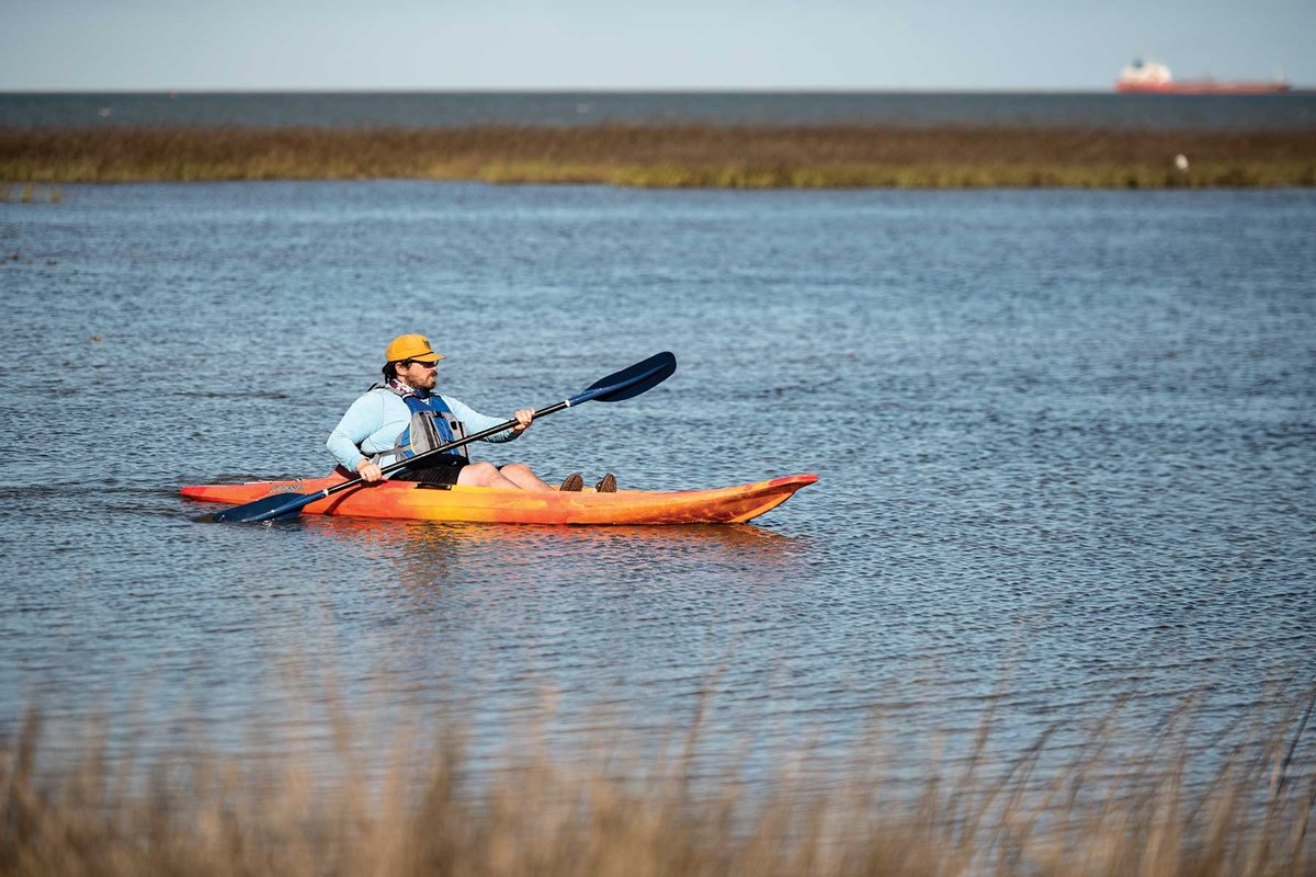 Man in a kayak on a paddling trail.