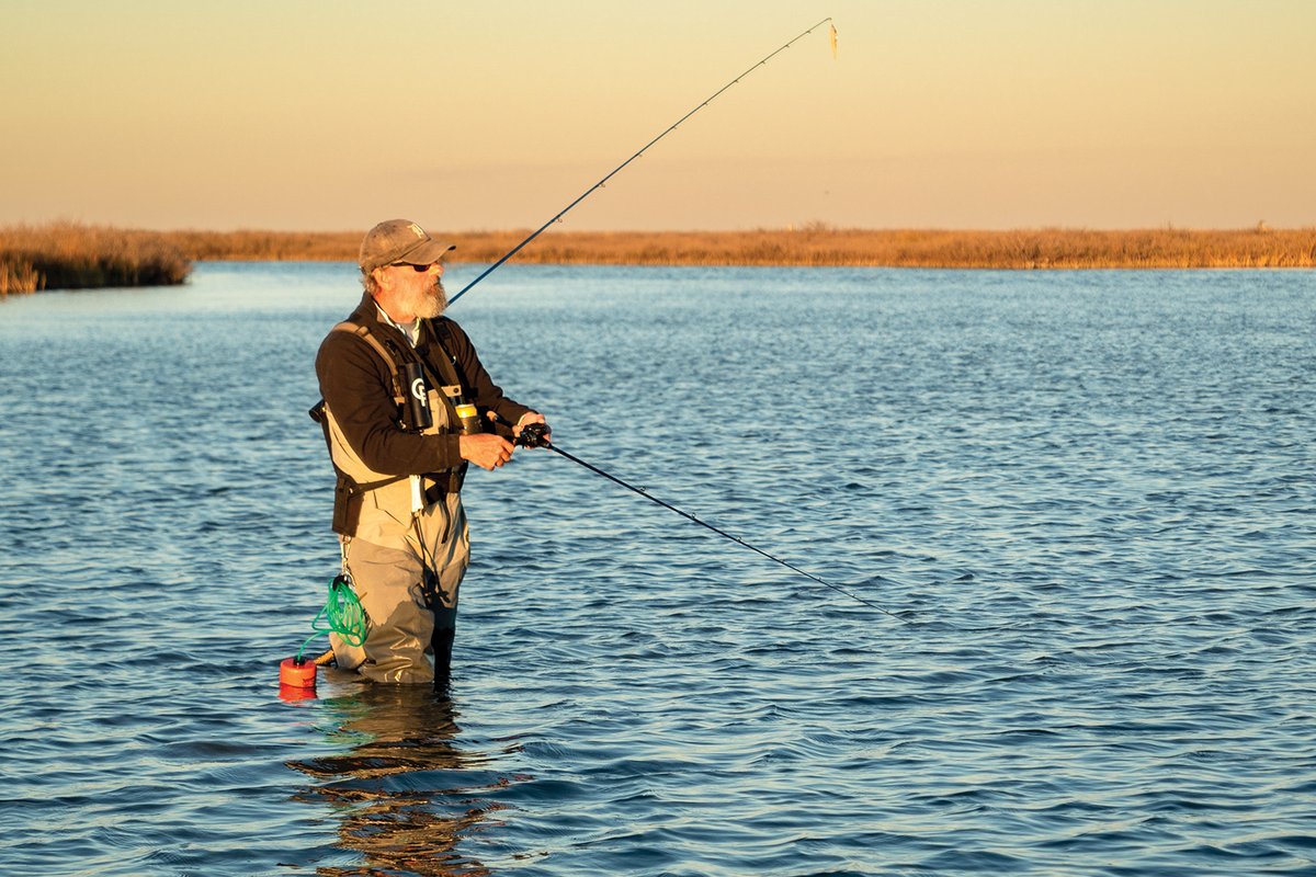 Man standing in the water fishing.