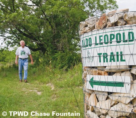 Man walking toward the trail head of Aldo Leopold Trail.