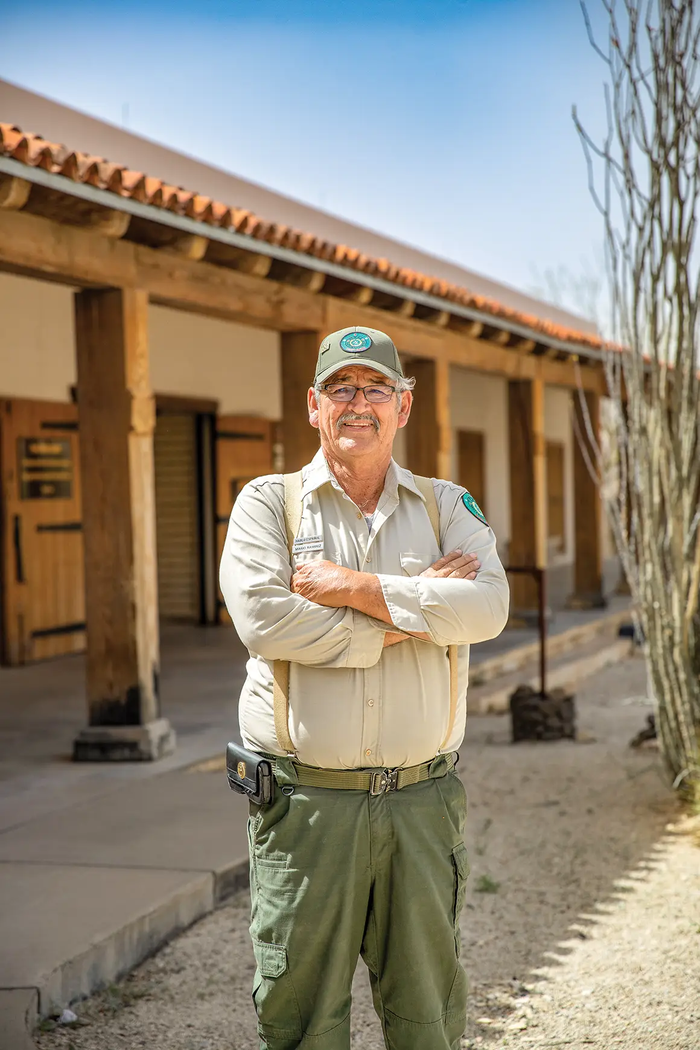 Mario Ramirez standing with arms crossed in front of a building at a Texas State Park