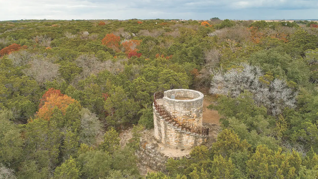 Mother Neff water tower surrounded by woods.