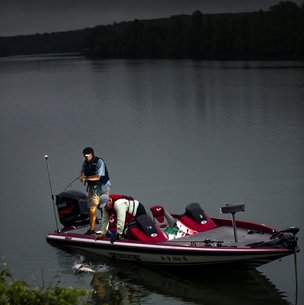 people on a boat bass fishing at night