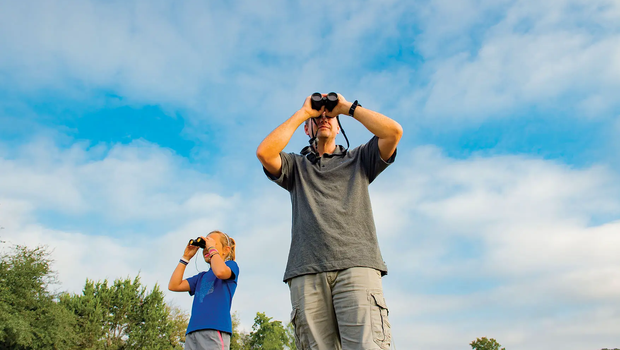 Couple viewing nature through binoculars