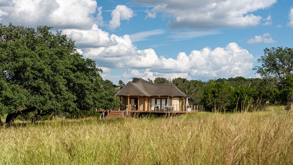 A cabin in a grassy field at Outdoorsy Hill Country.