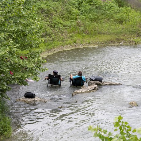 People relaxing with chair in the water at Palmetto State Park